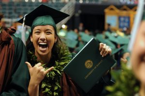 A happy UH graduate with her degree.