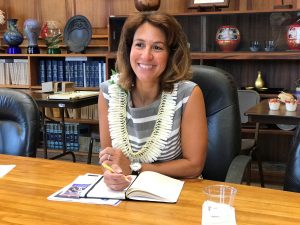 New DOE superintendent Dr. Christina Kishimoto smiles while writing in book