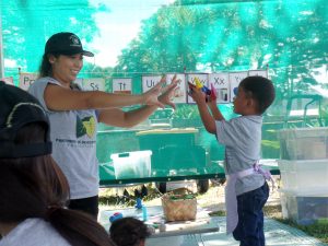 'OHANA NUI IN ACTION: Jessica Reyes, a Partners in Development mobile preschool staff member, counts with Relmersan, who was with his family at the Kaka'ako Family Assessment Center. The preschool program gives children a positive start.