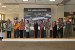 Kahu Kordell Kekoa (from left to right), HDOT Airport Division Deputy Director Ross Higashi, Rep. Richard Onishi, Airlines Committee of Hawaii Co-Chair Blaine Miyasato, House Vice Speaker Mark Nakashima, Governor David Ige, HDOT Director Jade Butay, Senate President Ronald Kouchi, Sen. Lorraine Inouye, Hawaiian Airlines President &amp; CEO Peter Ingram, Hensel Phelps Vice President Thomas Diersbock participate in the turning of the soil with O’o sticks.