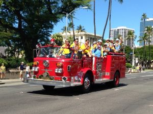 Team members wave to the crowds on their way to a celebration at Honolulu Hale.