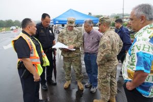 Hawai'i National Guard and police officers discuss emergency strategies with the governor.