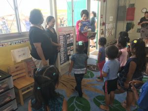 First lady Dawn Amano Ige reads to children at the blessing of Kahauike Village's new preschool.