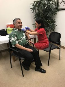 Following DOH advice, Governor Ige gets his seasonal flu shot from epidemiologist Sarah Park.