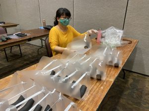 A volunteer assembles PPE purchased by the state Department of Health.