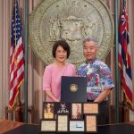 Governor and Mrs. Ige with photos of their dads.