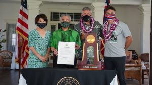 Governor Ige and the First Lady, coach Charlie Wade and team captain Colton Cowell with the NCAA trophy and proclamation.